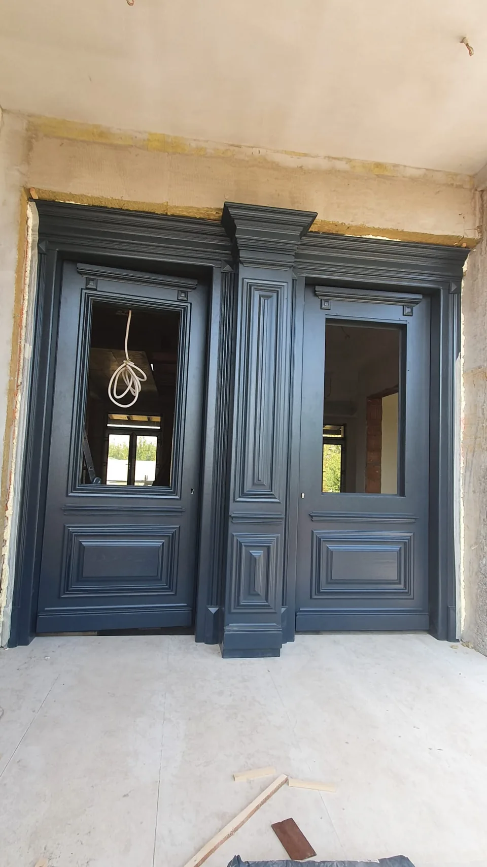 Ușă de intrare din lemn, cu panouri decorative.