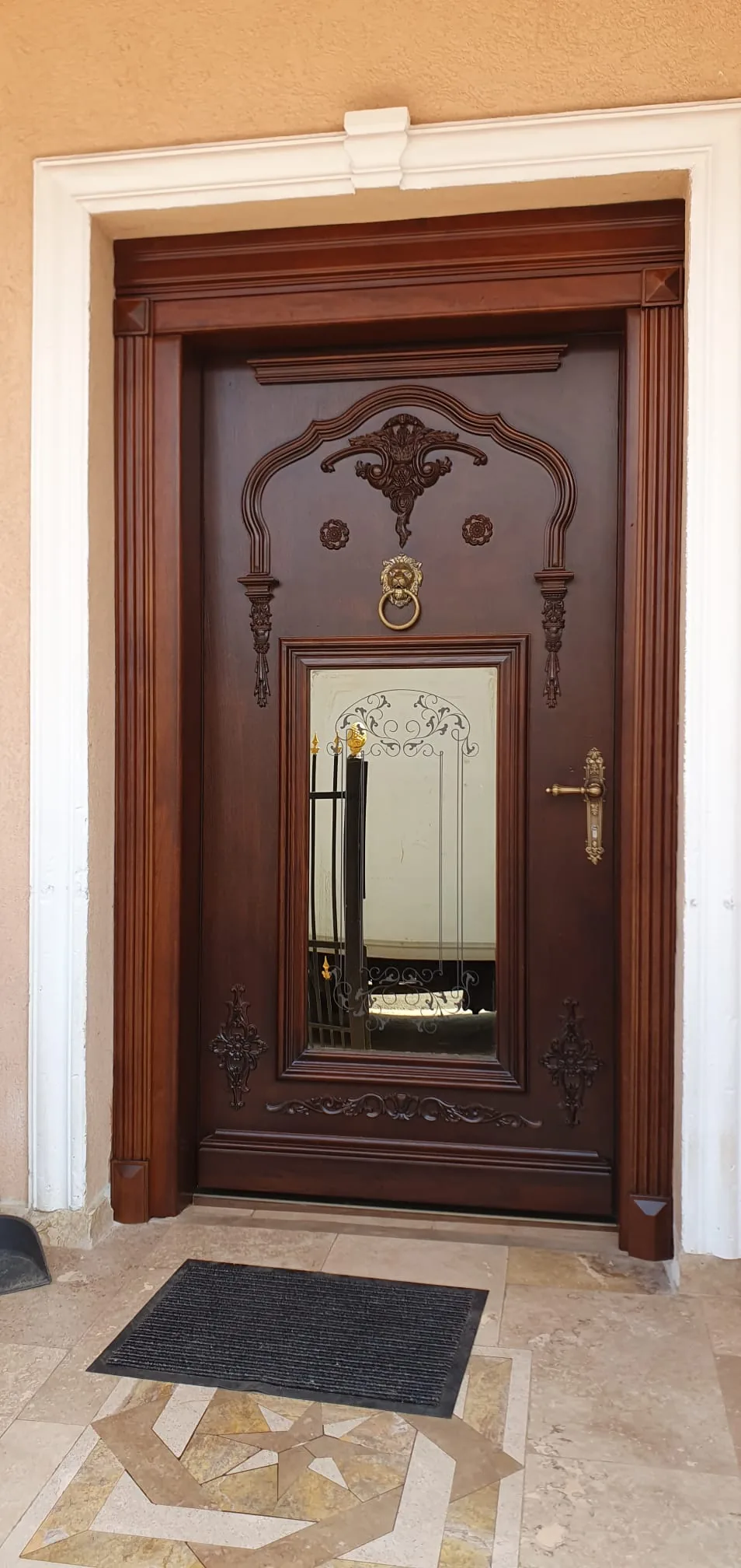 Ușă de intrare din lemn, cu panouri decorative.