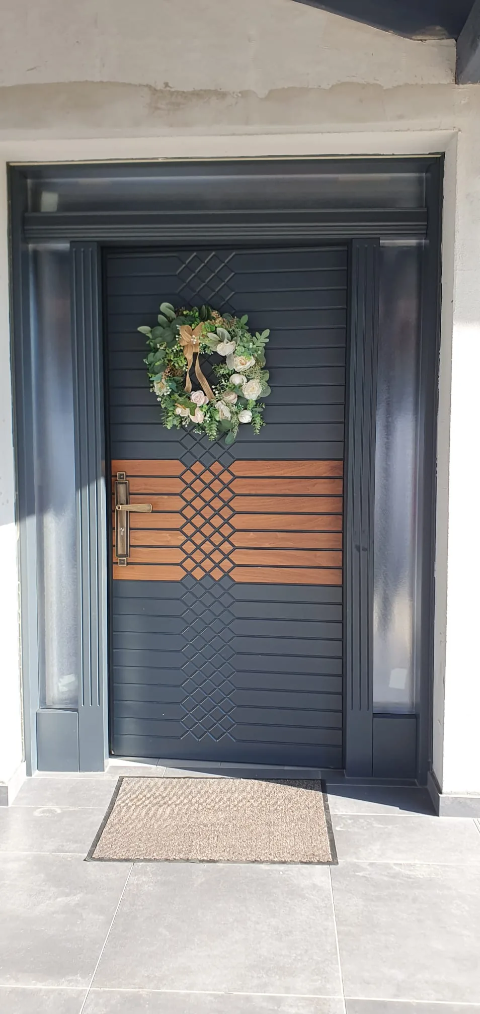 Ușă de intrare din lemn, cu panouri decorative.