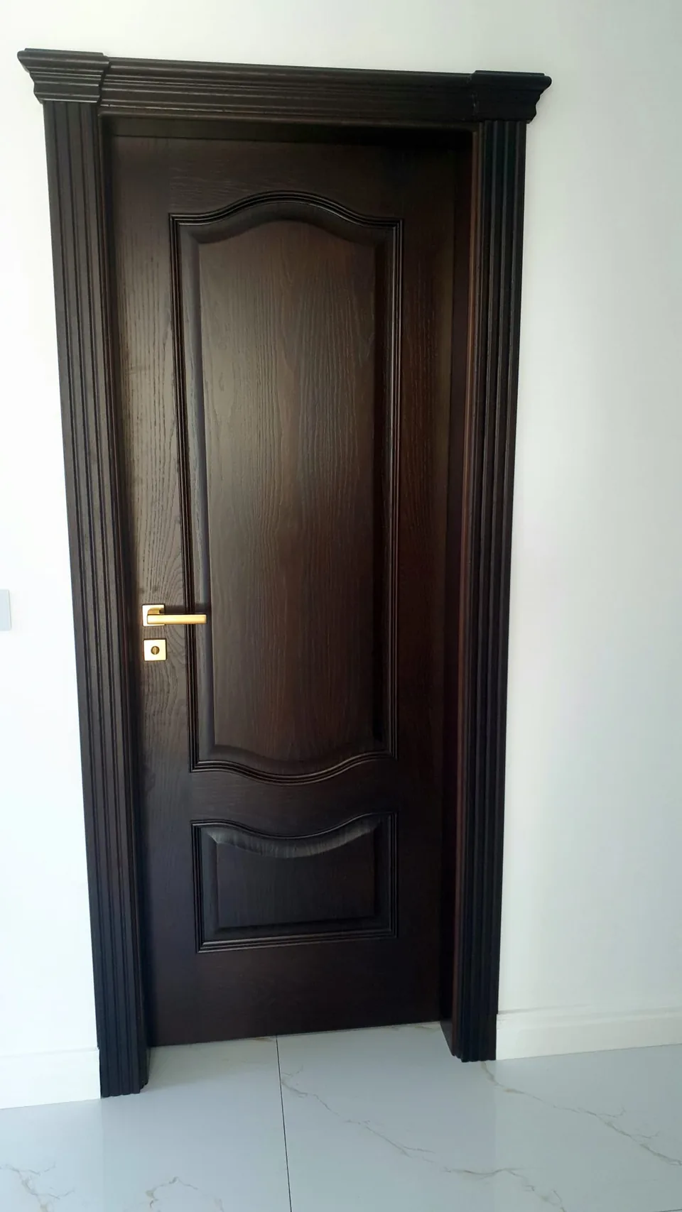 Ușă interioară din lemn cu panou profilat.