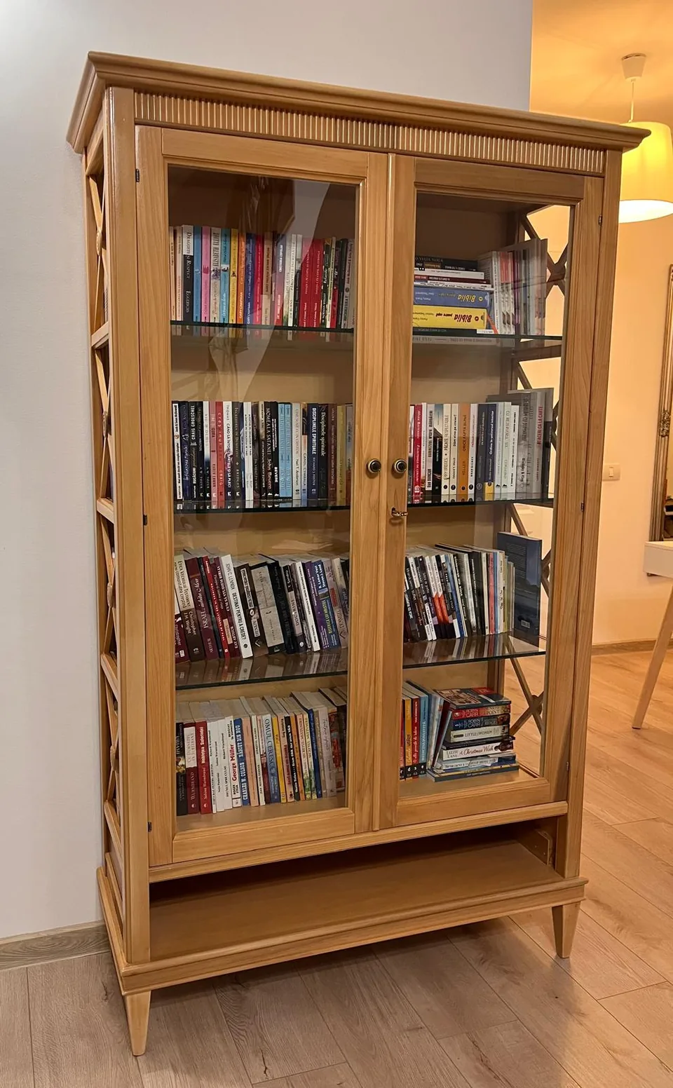 Bibliotecă din lemn cu uși vitrate.