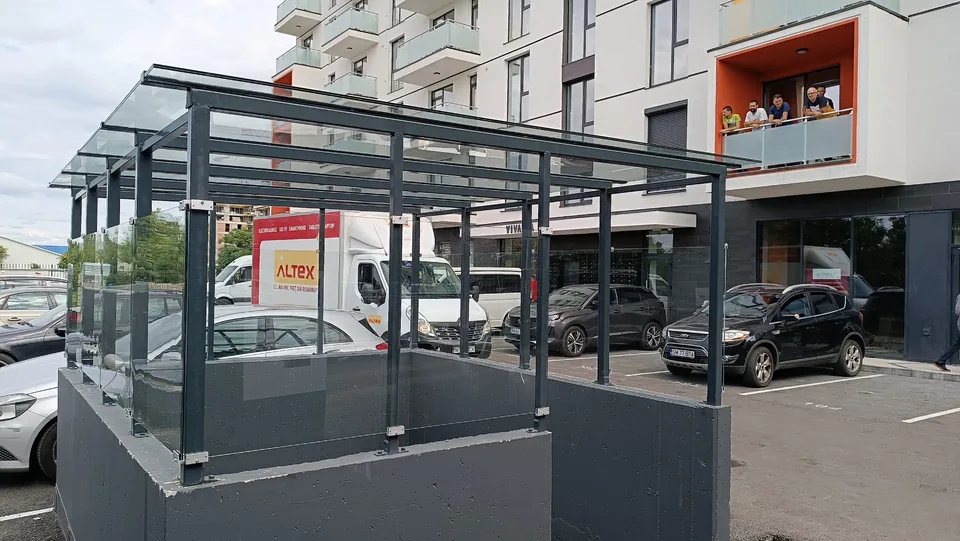 Structură metalică exterioară lângă o clădire comercială.