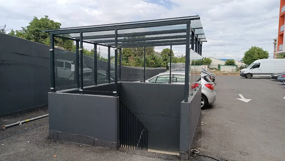 Structură metalică exterioară lângă o clădire comercială.